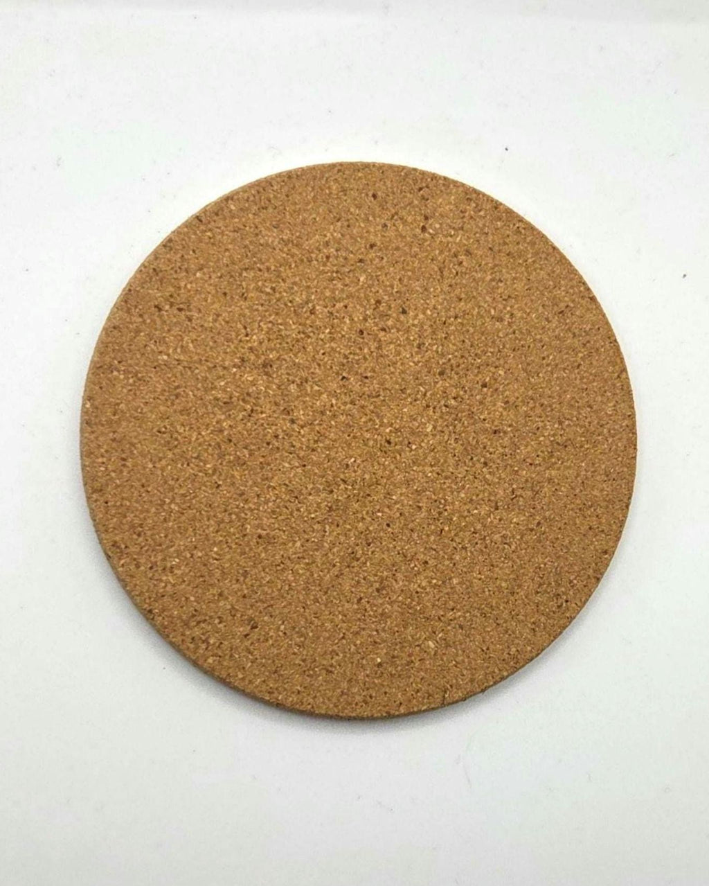 A round cork coaster with a natural tan-brown textured surface, photographed from directly above on a plain white background.