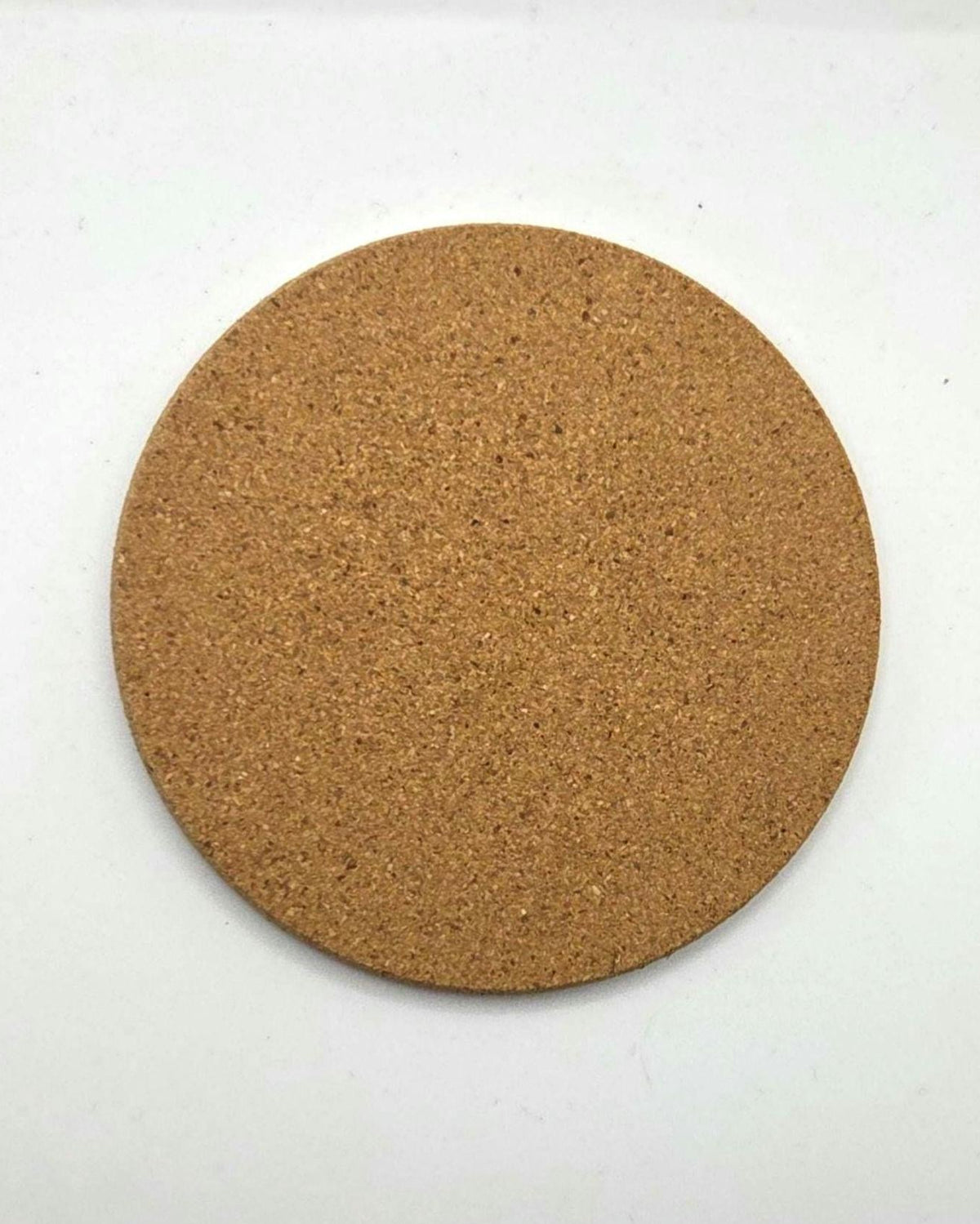 A round cork coaster with a natural tan-brown textured surface, photographed from directly above on a plain white background.
