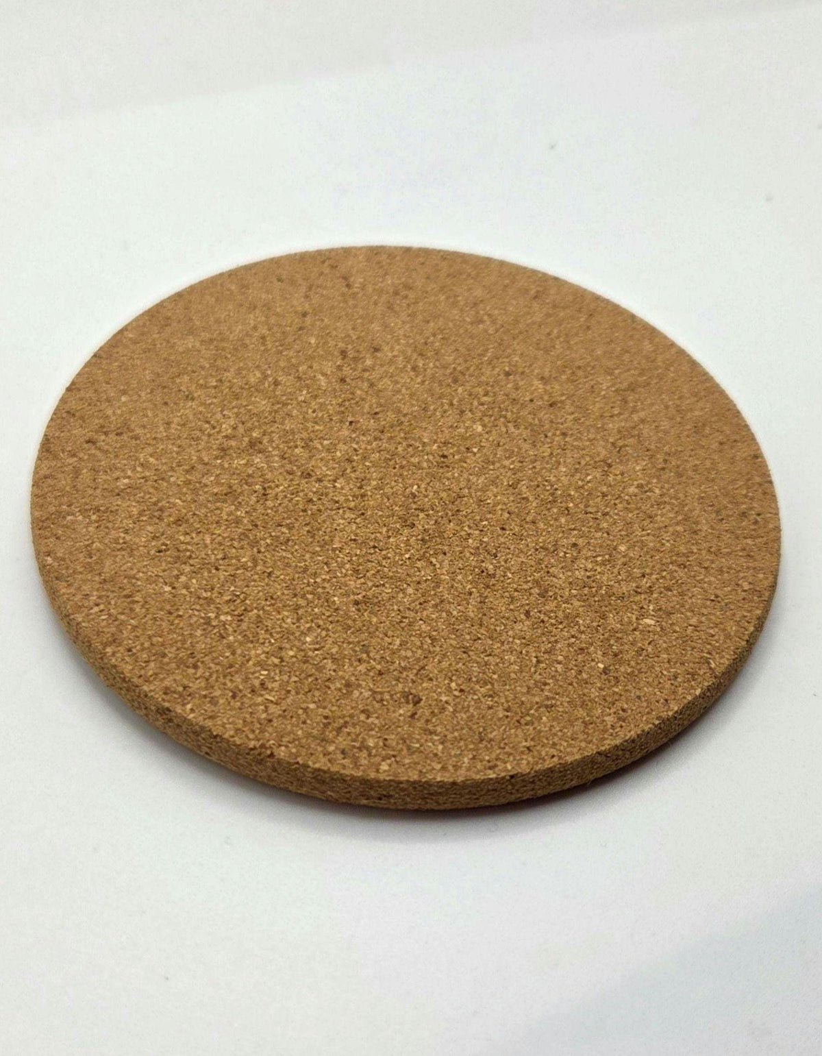 A round cork coaster with a natural brown textured surface, photographed on a plain white background.